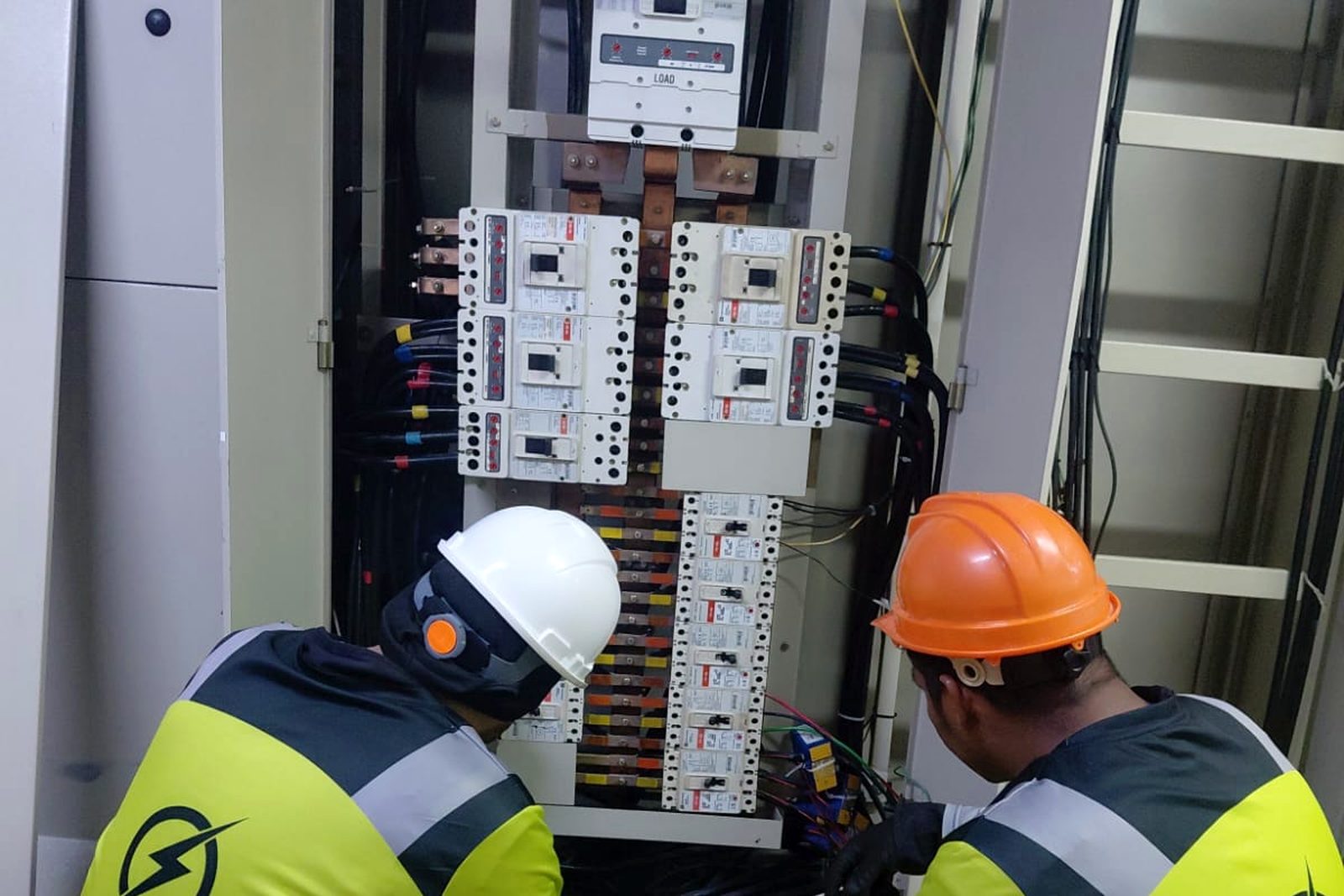 Técnicos de REMODEL BIS trabajando en tablero eléctrico industrial